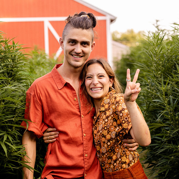 A couple smiling together in a hemp field